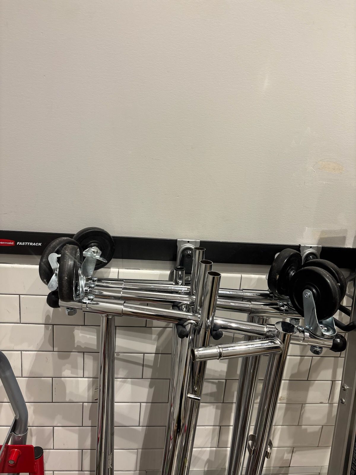 Wall-mounted hooks and track with stored carts and ladder