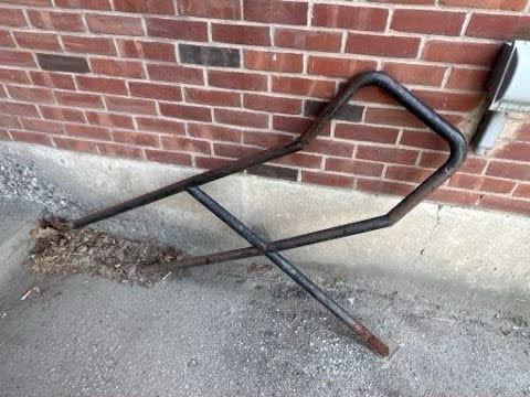 Detached metal railing beside a brick building