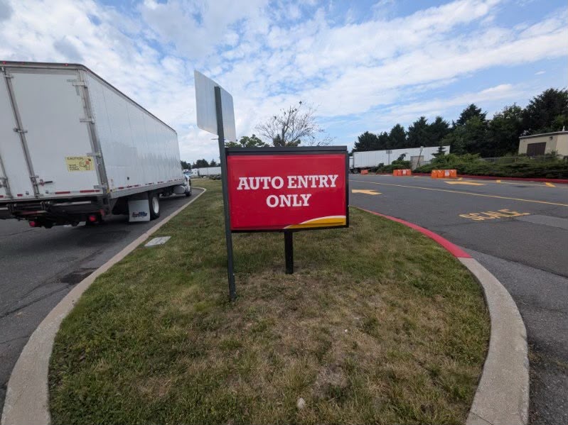 Vehicle entry sign beside a commercial access road