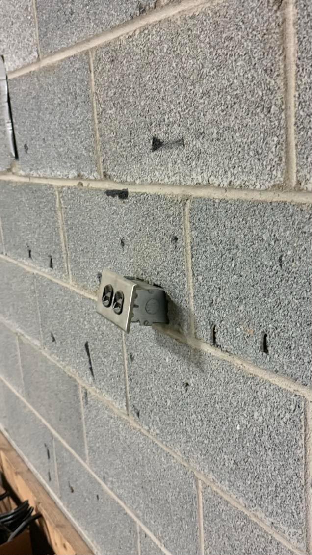 Electrical outlet box on a commercial masonry wall